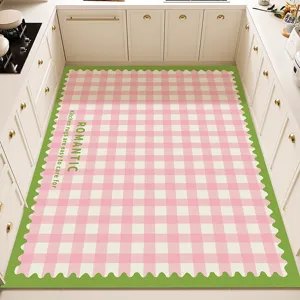 Vista detallada de una alfombra de cocina a cuadros rosas y blancos con borde ondulado verde.