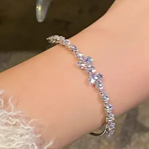 Closeup view of the sparkling rhinestone wheat bow bracelet worn on wrist, exquisite accessory.
