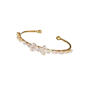 Elegant gold open cuff bracelet featuring sparkling cubic zirconia bow wheat design for women.