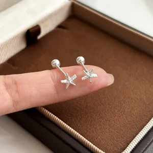 Nahaufnahme von Sterling Silber Seestern Ohrsteckern auf Finger in edler Schmuckschatulle.