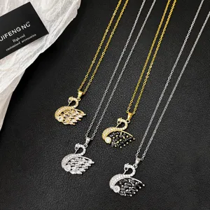 Close-up details of sparkling crystal swan pendant necklaces in gold and silver finishes.