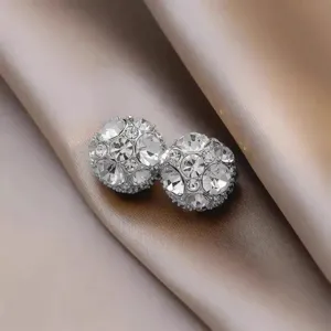 Nahaufnahme glitzernder Strass Magnetkugel Ohrringe, elegante Detailansicht polierter Kristalle.