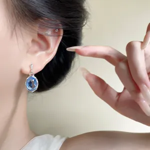 Primo piano dettaglio di orecchini pendenti in cristallo zircone blu, gioielli da orecchio.