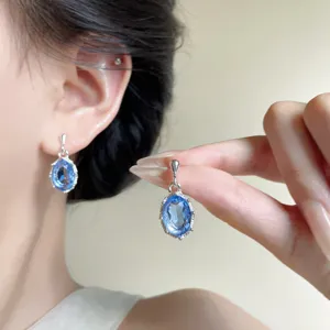 Primo piano dettagliato di orecchini pendenti in cristallo zircone blu, gioielli.