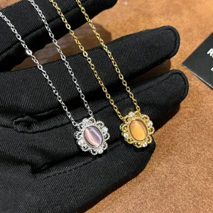Close-up of vintage French cat's eye stone lace pendant necklace detail in silver and gold.
