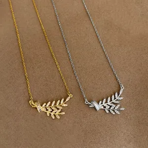 Close-up detail of dual-tone wheat spike zircon necklaces in gold and silver finishes.