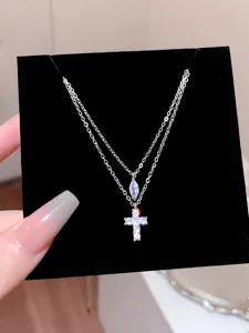Dainty double layer cross necklace featuring sparkling zirconia pendants and delicate silver chain.