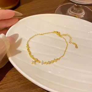 Exquisite close-up of delicate gold chain bracelet featuring sparkling star zirconia stones.