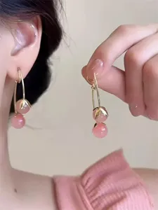 Detailaufnahme der rosa Kirsch-Ohrringe mit zarten goldenen Blättern und süßen Perlen.