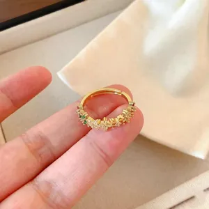 Detailaufnahme des filigranen Blumen-Offenrings mit bunten Zirkoniasteinen auf goldenem Band.