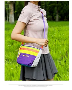 Detail view of the colorful outdoor crossbody shoulder bag worn by a model in nature.