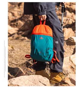 Lightweight foldable outdoor travel backpack in orange and teal, durable waterproof nylon material.