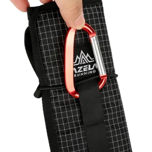 Outdoor portable folding camping mat storage pouch with red carabiner, black grid fabric