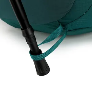 Close-up view of hiking backpack frame connection detail, durable green fabric and metal rod.
