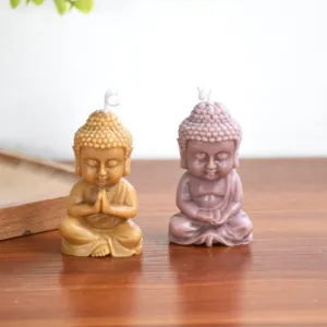 Primo piano dettagliato di simpatiche piccole candele fatte a mano a forma di Buddha.