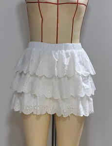White tiered ruffle mini skirt with delicate eyelet embroidery and elastic waist for women.
