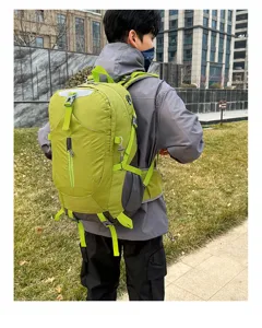 Gedetailleerd overzicht van de groene 40L wandelrugzak gedragen, met schouderbanden en gaasvakken.