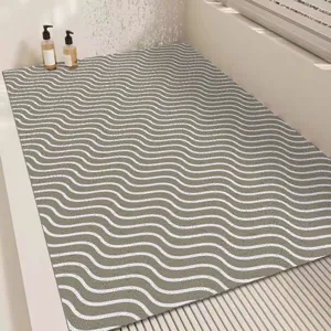 Detailed view of modern minimalist grey bath mat with white wave pattern, non-slip PVC material.