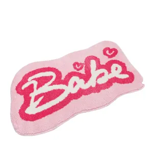 Pink fluffy rug with white Babe script text, soft non-slip floor mat for bathroom bedroom.