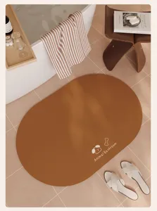 Vista dettagliata del tappeto bagno ovale marrone con simpatico motivo in stanza piastrellata.