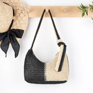 Detail view of black white woven straw shoulder bag, casual chic beach purse with knot detail.