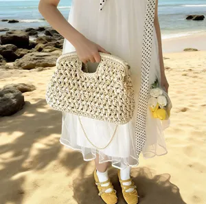 Detailed view of women's woven straw shell handbag with chain strap for beach vacation.