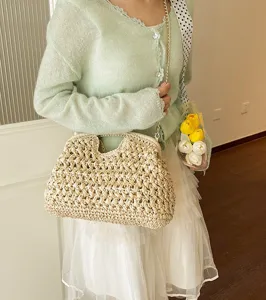 Detailed view of the retro paper-rope straw woven shell handbag with chain strap for women.