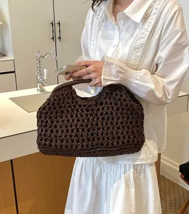 Detail shot of the brown woven straw clutch bag, showing texture and lifestyle scene.