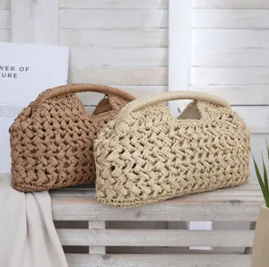 Detailed view of the woven straw clutch bag with unique hollow design and rustic style.
