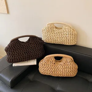 Close-up of woven straw clutch bags featuring unique shell shapes, textured paper rope and chic style.