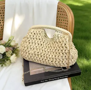Detail shot of woven straw shell handbag with chain strap, natural material forest style accessory.