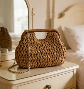Detailed view of retro straw woven handbag with metal chain strap and top handle. Detail shot.