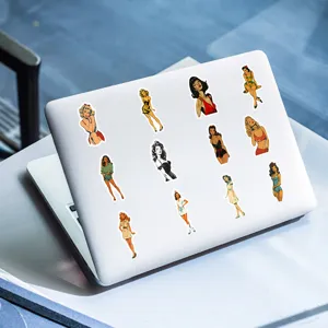 Detailed view of retro pin-up girl stickers applied on a clean white laptop surface.