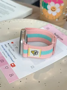Detailopname van elastische gestreepte horlogeband met magneetsluiting en leuk label.