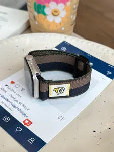Gedetailleerd overzicht van de gestreepte magnetische horlogeband met een leuk geweven patch.