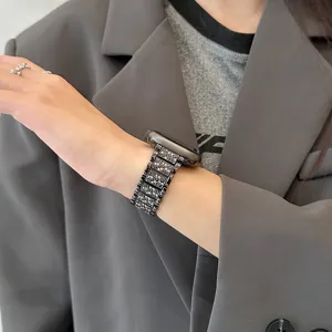 Dettaglio cinturino smartwatch in metallo con strass brillanti, elegante cinturino a maglie grigio.