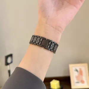 Dettaglio cinturino per orologio in metallo nero con strass e cristalli brillanti.