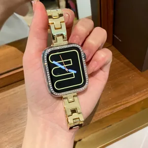 Vista dettagliata del cinturino orologio H in metallo dorato con custodia in strass.