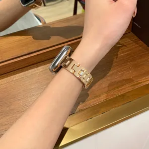 Primo piano dettagliato del cinturino per orologio in metallo H-link oro rosa indossato al polso.