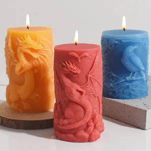 Primer plano detallado de velas de pilar esculpidas con dragones y cuervos en relieve.