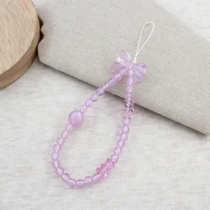 Detailed close-up of a sweet pink beaded phone strap featuring a cute bow and charming design.