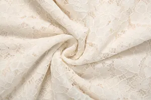 Detailopname van witte kanten bloemstof met een fijn opengewerkt patroon en mooie textuur.