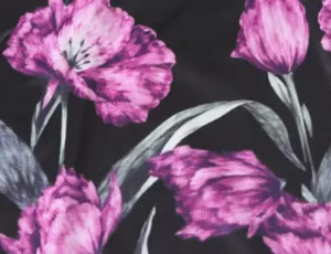 Gedetailleerd overzicht van de zwarte gebreide stof met levendige paarse bloemenprint.