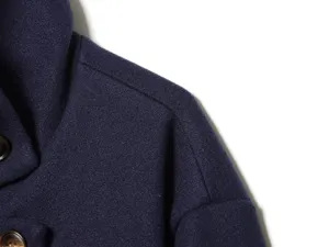 Detail shot of women's navy blue wool blend short jacket shoulder and lapel collar.
