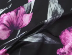 Detailopname van de elastische gebreide stof met bloemenprint voor zomerjurken.