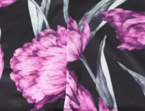 Close-up van zwart en magenta bloemen gebreide stof detail, elastisch materiaal, textuur.