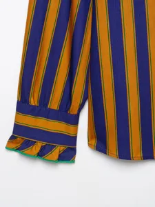 Close-up of women's long sleeve striped shirt cuff, detailed ruffles, vibrant color design.