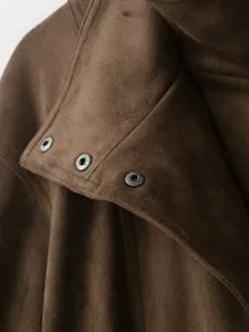 Close-up detail of brown suede jacket collar with metallic snap buttons and fine stitching texture.