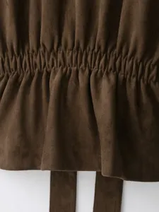 Detailed close-up view of brown faux suede fabric featuring elastic waist shirring design.