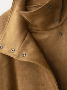 Close-up detail shot of women's camel suede jacket collar featuring sleek metallic snap buttons.